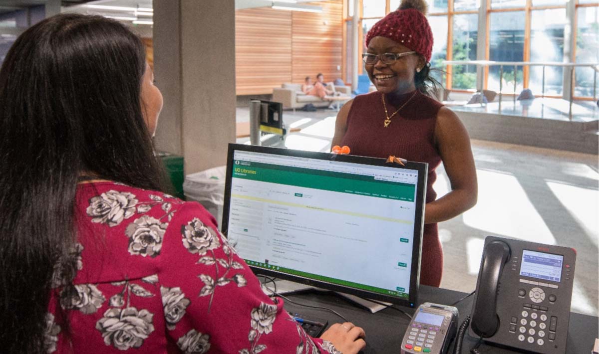 A student talking to a librarian at their desk