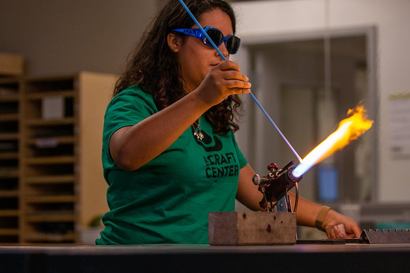 Student using a torch in the Craft Center.