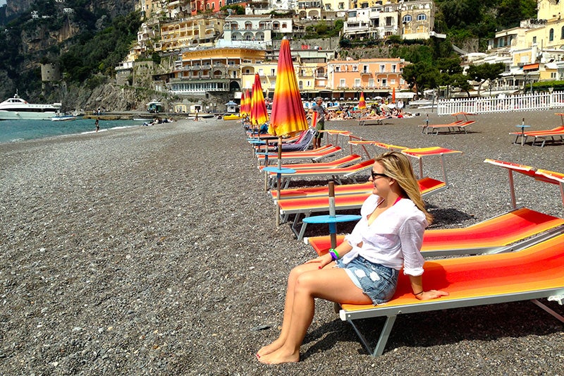 Student sitting on a beach in Positano.