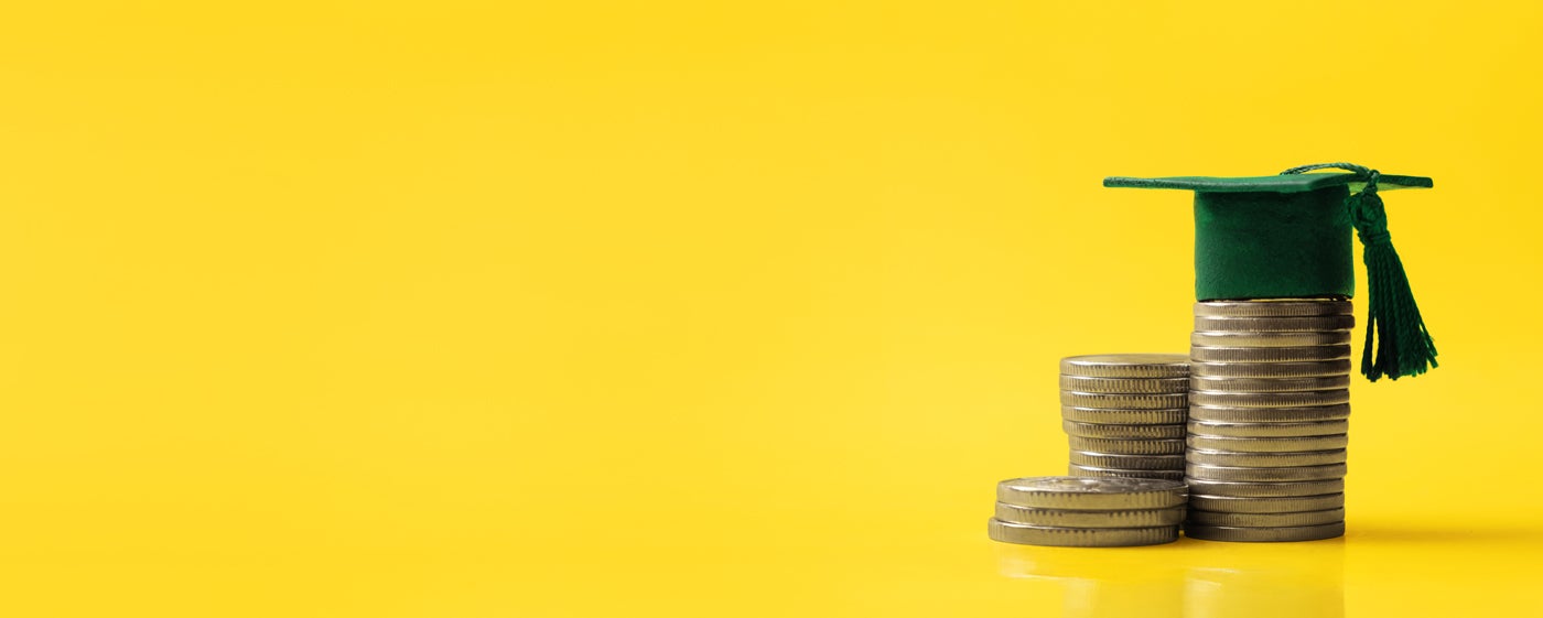 Coins and mortarboard on yellow background